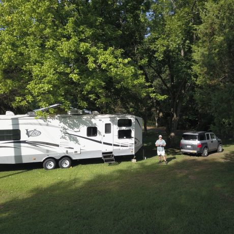 rv parked in grassy area with trees