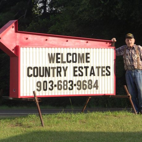 man standing with signage for Country Estates